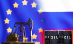 Una imagen de archivo muestra miniaturas de barriles de crudo frente a las banderas de Rusia y la UE