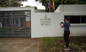 Una mujer toma una fotografía de la fachada de la Academia Nicaragüense de la Lengua(Nicaragua)