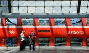 Dos personas esperan un tren regional en la Estación Central de Berlín después de que Alemania aprobase una tarifa plana de transporte público para bajar el consumo de carburantes y hacer frente a la crisis.