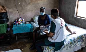 Phenduka Mtshali, una paciente con tuberculosis resistente a los medicamentos (DR-TB), en su casa en Mbongolwane, Sudáfrica, hablando con un trabajador de campo de MSF.