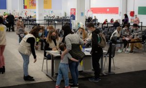 07/06/2022. Una familia de refugiados ucranianos con voluntarias traductoras, en el centro de refugiados ucranianos, en la Fira de Barcelona, a 8 de abril de 2022.