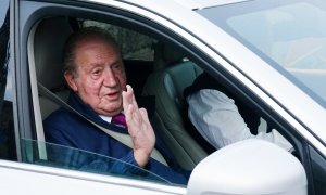 El rey emérito Juan Carlos I saluda desde un vehículo a su salida de la casa de Sanxenxo camino de Madrid, a 23 de mayo de 2022, en Sanxenxo.