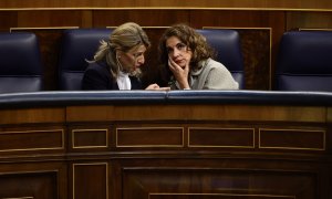 La vicepresidenta segunda y ministra de Trabajo, Yolanda Díaz, y la ministra de Hacienda y Función Pública, María Jesús Montero, conversan en sus escaños del Congreso de los Diputados. E.P./Eduardo Parra