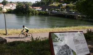 Un ciclista pasa por las inmediaciones del río Bidasoa a su paso por Irún este sábado.