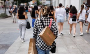 21/06/2022-Una mujer pasea con bolsas por la Gran Vía, a 21 de junio, en Madrid