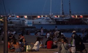 Un grup de gent sopa a la platja del Somorrostro de Barcelona a la revetlla de Sant Joan.