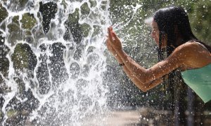 10/07/2022 Una mujer se refresca en una de las fuentes del centro de Córdoba este domingo