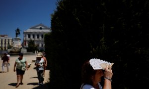 Una se protege del sol con un abanico durante la segunda ola de calor del año en Madrid.