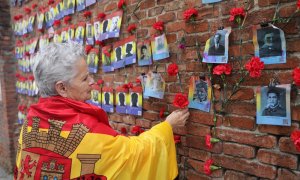 14/07/2022. Una mujer coloca una rosa en una pared durante una ofrenda floral y encuentro abierto entre familiares de las víctimas y estudiantes daneses del franquismo, en el cementerio de La Almudena, a 12 de abril de 2022, en Madrid