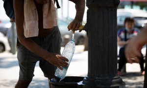Un hombre rellena una botella de agua en una fuente en el parque de la Barceloneta, a 13 de julio de 2022, en Barcelona, Catalunya (España).