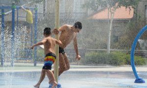 (14/7/2022) Dos jóvenes se refrescan en unos chorros durante un día de la segunda ola de calor de verano en España, a 14 de julio de 2022, en Ourense.