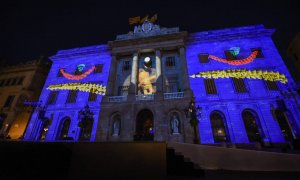 El logotip i la mascota dels Jocs Olímpics de Barcelona, en un 'mapping' a la façana de l'Ajuntament per commemorar el 30è aniversari de l'esdeveniment.