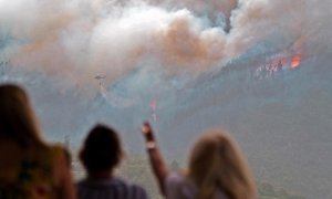 Vecinos del barrio de Las Llanadas, en el municipio tinerfeño de Los Realejos, observan el incendio que afecta al norte de la isla.