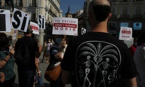 Un grupo de personas se reúne sosteniendo pancartas y carteles durante la concentración de la asociación Derecho a Morir Dignamente (DMD) en la Puerta del Sol, a 25 de junio de 2021, en Madrid, (España).