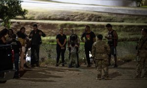 Los migrantes son detenidos por tropas de la Patrulla Fronteriza y la Guardia Nacional de EE. UU. en Eagle Pass, Texas, cerca de la frontera con México, el 30 de junio de 2022.