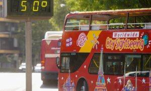 25/07/2022-Un autobús turístico pasa sin pasajeros delante de un termómetro que marca 5Oº en otro día con altas temperaturas en la capital andaluza a 25 de julio del 2022 en Sevilla (Andalucía)