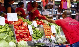 Un hombre compra en un puesto de fruta y verduras de un mercado de Madrid.
