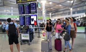 (1/7/2022) Varias personas consultan las salidas y llegadas de los aviones en el aeropuerto Costa del Sol de Málaga, a 1 de julio de 2022.