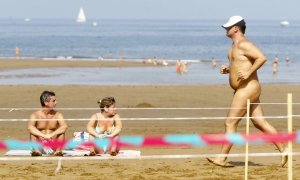 (9/09/06) Una pareja toma el sol mientras un hombre participa en la carrera nudista "Patxi Ros" de Sopelana (Euskadi), a 9 de septiembre de 2006.