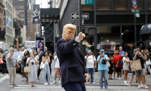 Un hombre con una máscara del expresidente estadounidense Donald Trump es fotografiado por turistas en la Quinta Avenida frente a la torre Trump en Nueva York, Nueva York.