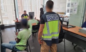 Migrantes hablando con miembros de la Policía Nacional.