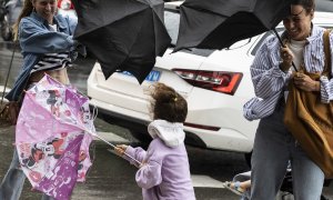 18/8/22 Varias personas tratan de dominar sus paraguas en Donostia, a 18 de agosto de 2022.