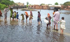 Varias familias tratan de atravesar una zona inundada en la provincia de Sindh.
