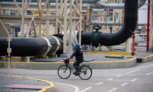 Un trabajador monta en bicicleta en la planta de regasificación de Enagás, en Barcelona, a 29 de marzo de 2022.