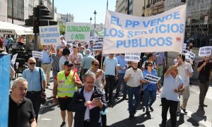 Varias personas sujetan una pancarta en la que se lee: 'El PP vende los servicios públicos' durante una marcha contra la reforma de la Ley de Transportes, a 1 de junio de 2022, en Madrid (España).