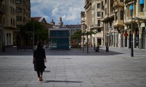 Una mujer camina por la comercial Avenida Carlos III de Pamplona, prácticamente vacía por sus tiendas cerradas durante el estado de alarma decretado por la pandemia de la covid-19. E.P./Eduardo Sanz