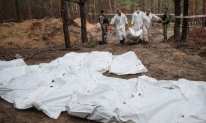 Técnicos mueven los cuerpos hallados en una fosa común en la ciudad de Izium, a 16 de septiembre de 2022.