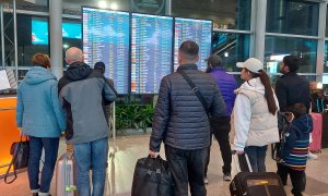 Varias personas comprueban el estado de sus vuelos en las pantallas del aeropuerto de Domodédovo en Moscú, Rusia