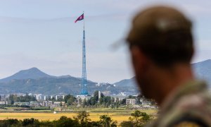 Un soldado de Naciones Unidas divisa una bandera de Corea del Norte desde la zona desmilitarizada que separa las dos Coreas, a 4 de octubre de 2022.