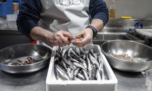 Un vendedor limpia pescado en un puesto de pescado en el Mercado Central de Valencia, a 24 de marzo de 2022, en Valencia, Comunidad Valenciana, (España).