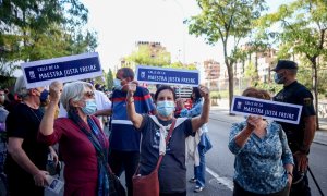 Tres mujeres muestran pancartas en las que figura una placa para la Calle Maestra Justa Freire, en una manifestación para que su nombre vuelva a la que hoy es la calle General Millán-Astray.