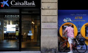 Un hombre utiliza el cajero automático de una sucursal de Caixabank en Barcelona. REUTERS/Nacho Doce