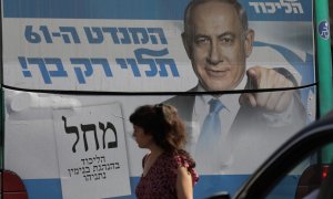 Una mujer pasa junto a una valla publicitaria del ex primer ministro israelí y líder del partido Likud, Benjamin Netanyahu, en Jerusalén, Israel.