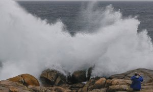 Un turista fotografía las olas en Muxía (A Coruña).