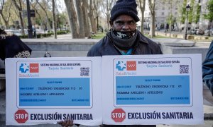 Un manifestante porta un cartel durante una concentración en la que se ha entregado un manifiesto al Ministerio de Sanidad contra la exclusión sanitaria, frente al Ministerio de Sanidad, a 7 de abril de 2022, en Madrid (España).