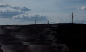 Una línea de alta tensión en el horizonte, cerca de los paneles de un parque solar, en la localidad de Saelices (Cuenca). REUTERS/Susana Vera