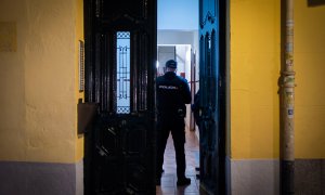 Un agente de Policía en el portal del edificio donde han hallado muerta a un joven de 20 años, a 28 de noviembre de 2022.