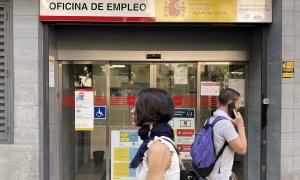 Dos personas pasan por la oficina de empleo de Acacias, a 4 de octubre de 2022, en Madrid.
