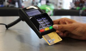 Una persona paga con una tarjeta bancaria, en una imagen de archivo