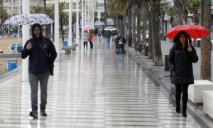 Turistas bajo la lluvia, el pasado viernes, en el paseo de Benidorm