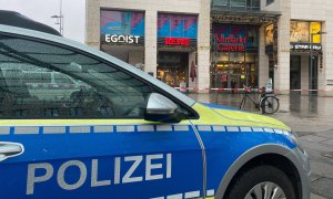 Fotografía de un coche policial frente al centro comercial en el que se ha activado el operativo policial, en Dresde, Alemania.