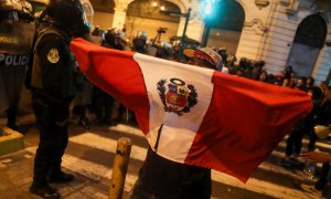 Un manifestante sostiene una bandera de Perú durante las protestas en Lima tras la proclamación del estado de emergencia, a raíz de la movilizaciones por la destitución del presidente Pedro Castillo. REUTERS/Sebastian Castaneda