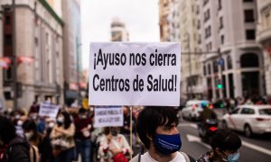 Un hombre protesta por la sanidad pública en Madrid con una pancarta que reza: "Ayuso nos cierra centros de salud"