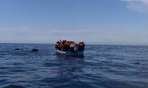 Imagen de archivo de varias personas migrantes en un bote de madera, antes de ser rescatadas por la ONG Open Arms.
