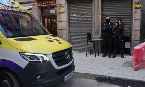 Dos agentes de la Ertzaintza en la puerta de la taberna Hiargi, donde una mujer ha sido asesinada por su pareja en Bilbao, a 28 de diciembre de 2022.