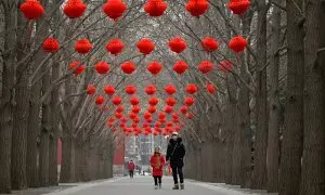 Una niña y su padre caminan por Pekín en la víspera del año nuevo chino.